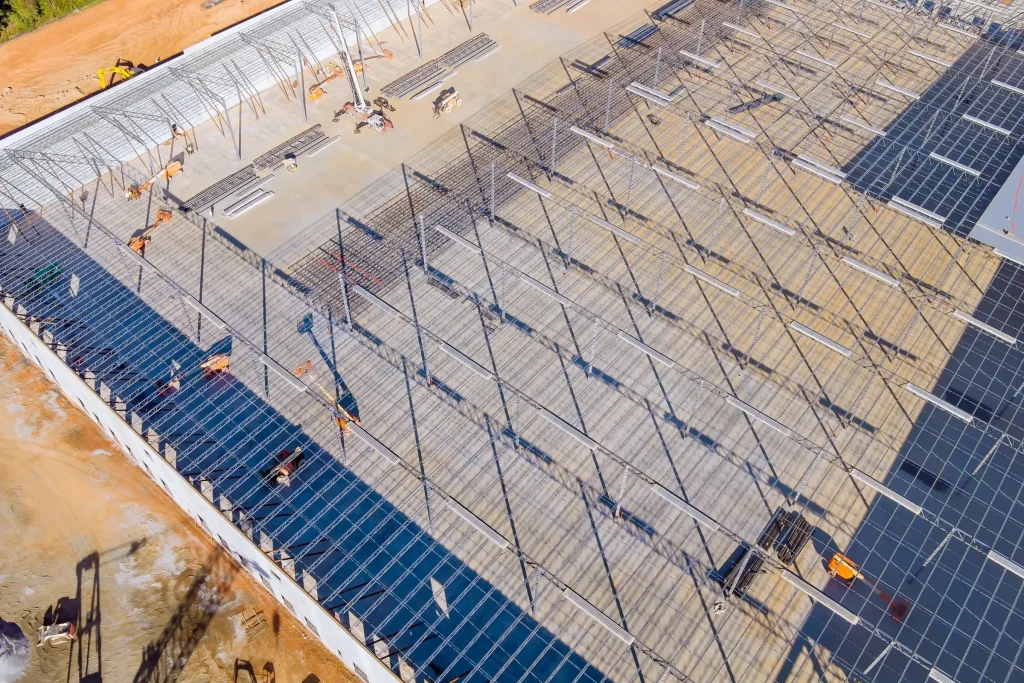 Construction workers installing steel mounting frames at a solar farm