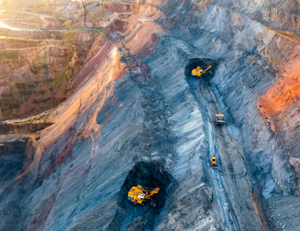Aerial view of an open-pit mine with excavators and haul trucks